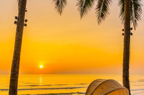 Umbrella and deck chair on the beautiful beach and sea at sunrise time for travel and vacation
