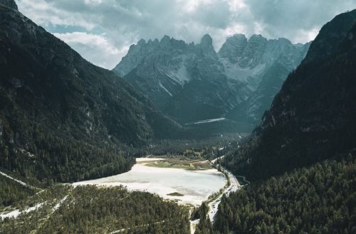 A vertical shot of green mountains with white clouds in the background